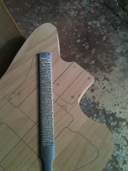 Filing the edges of the guitar