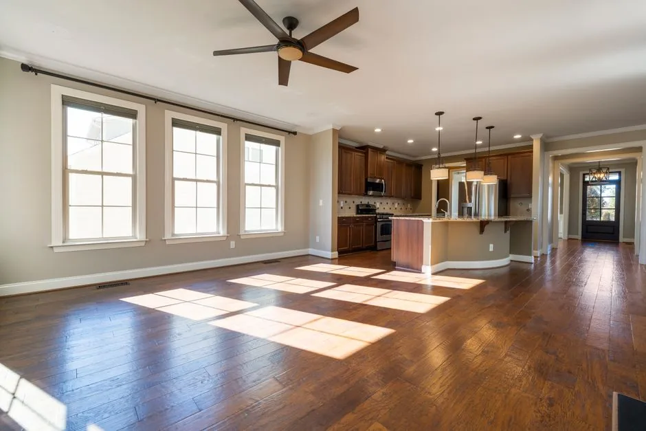 How To Use a Generic Remote with your Ceiling Fan? 6 Sunlit kitchen and living area with hardwood floors representing a home with an updated ceiling fan remote system