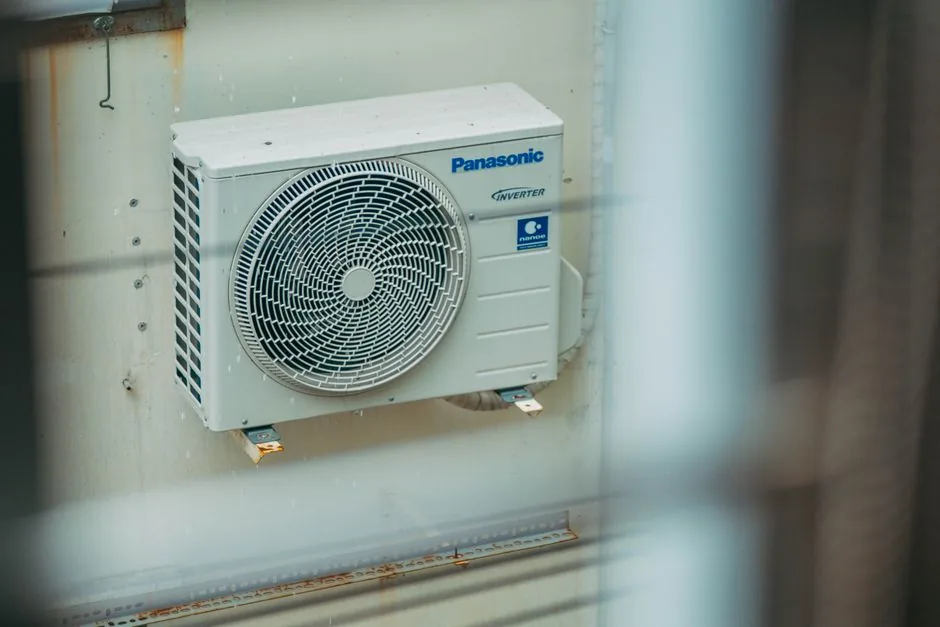 HVAC Repair Cost Guide: Capacitor, Compressor, Refrigerant Explained 4 Air conditioner unit mounted outdoors on a building wall, showcasing modern HVAC technology.