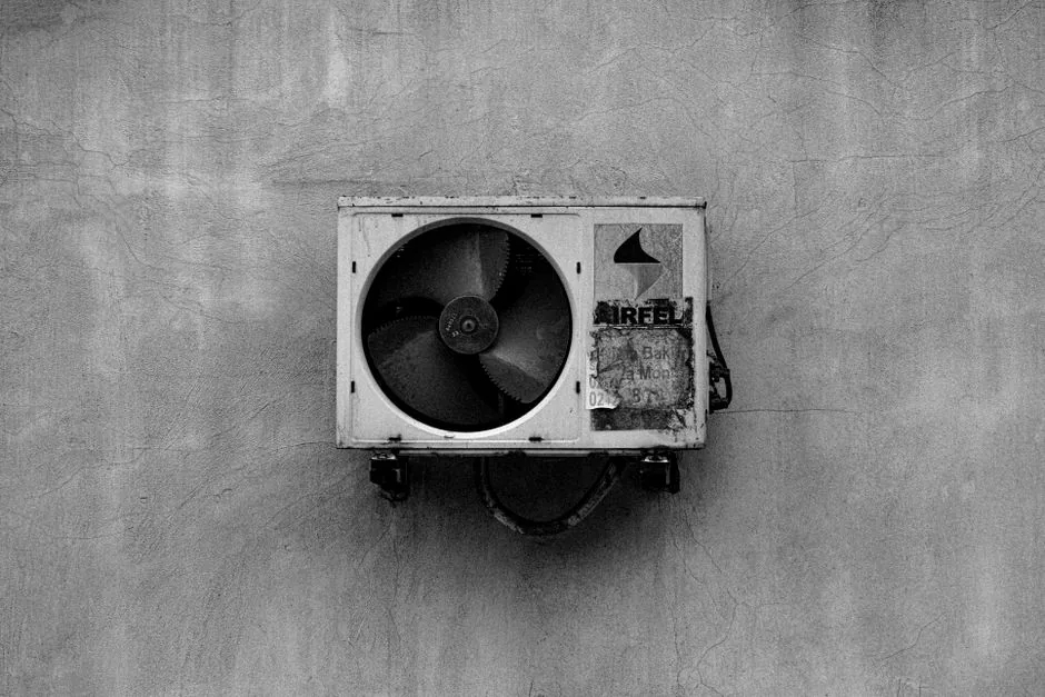 Ductless Mini-Split vs Central AC: Cost and Efficiency Compared 4 Monochrome image of a wall-mounted air conditioner on a concrete surface.